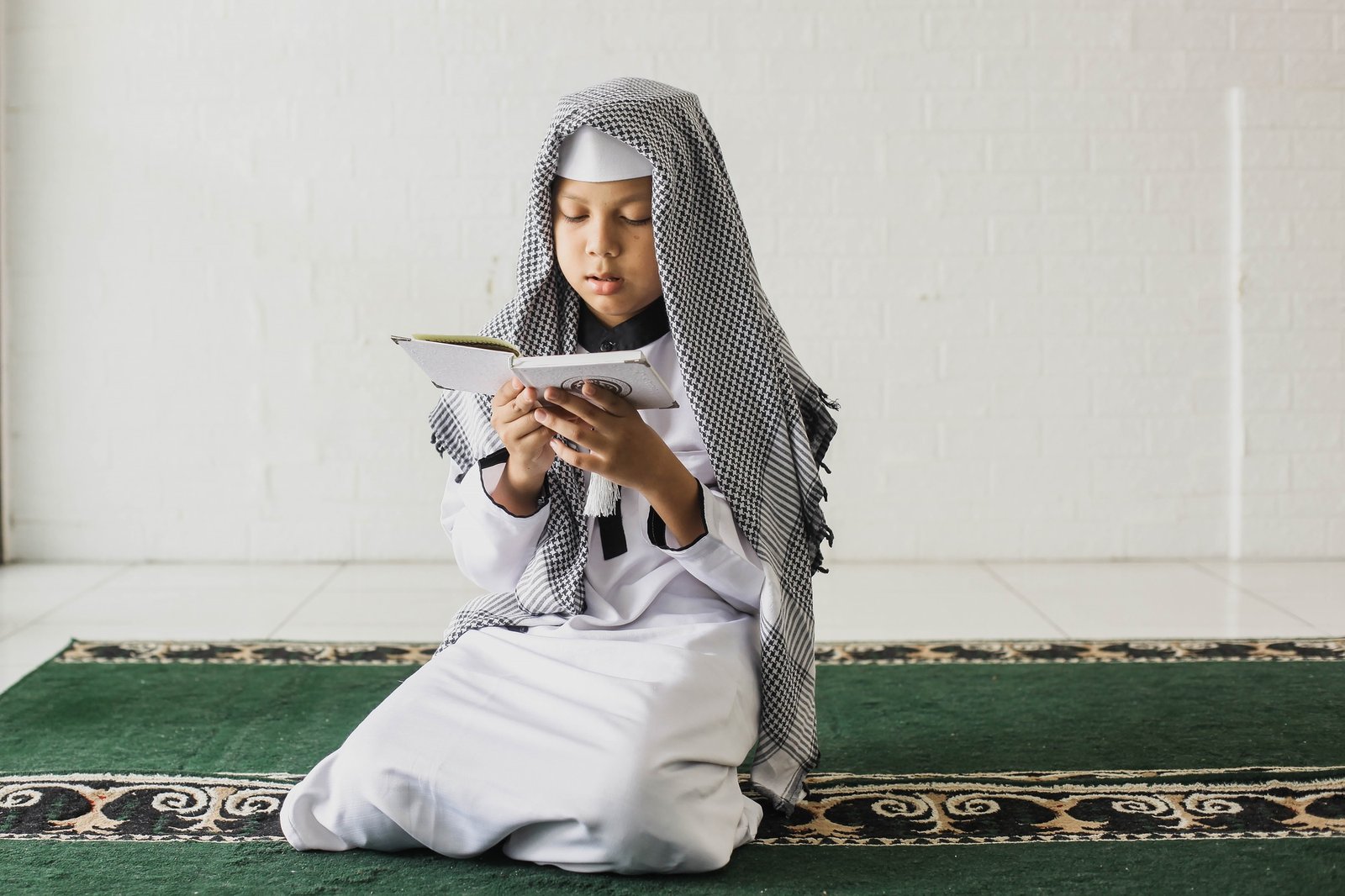 Muslim boy reading Quran in the mosque