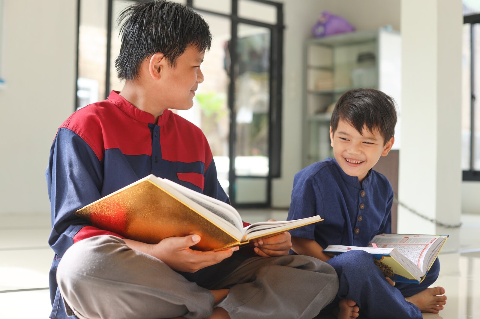 Two happy kids reading holy Quran together during ramadan
